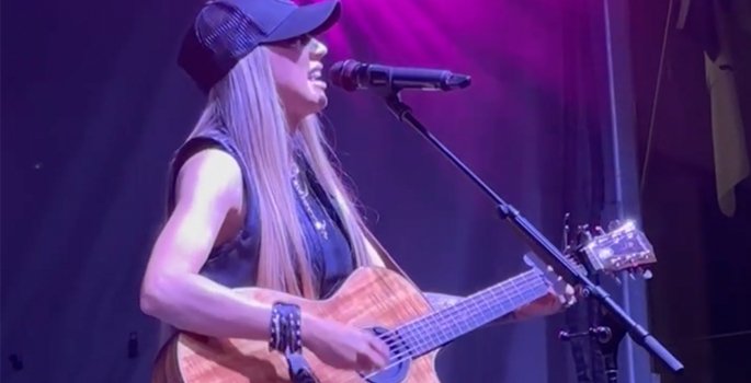 Ali Walker on stage playing guitar