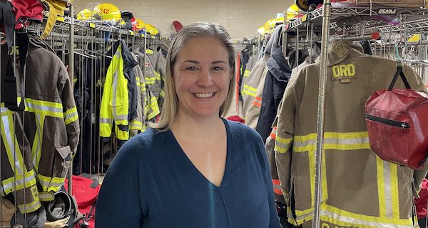Photo of a female staff person in a room of firefighting equipment