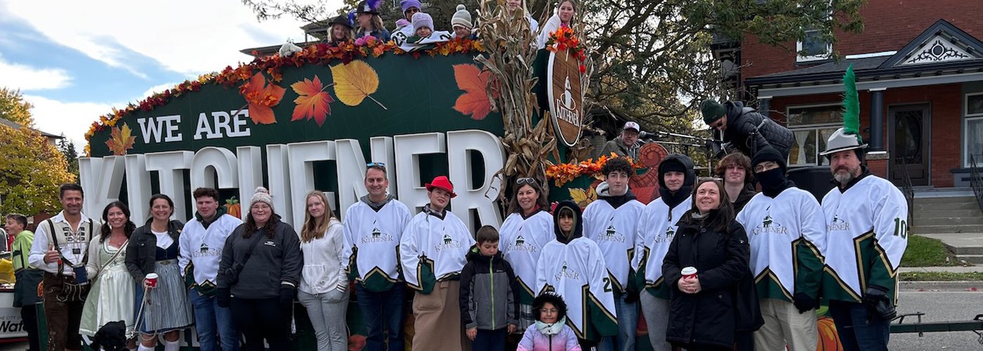 Group of staff and volunteers in front of Kitchener float