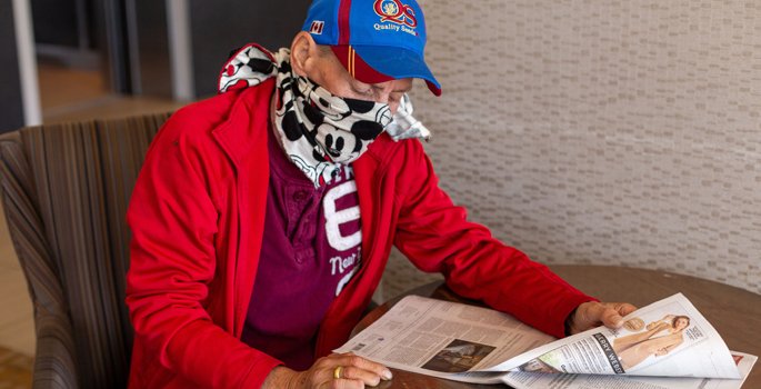 Person sitting at table reading the newspaper