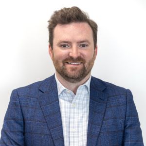 Nick Burke Man in a suit looking at the camera on a white background