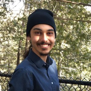 Josh Rampersad Man wearing a beanie in a forest looking at the camera